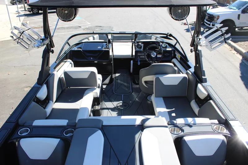Slide: The Image of 2019 Heyday WTSurf boat interior with seating and steering wheel, parked on pavement. - 14