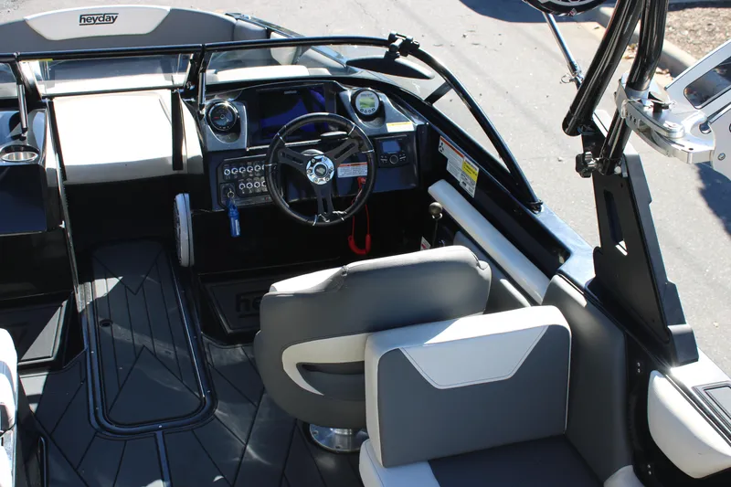 Slide: The Image of Interior of a 2019 Heyday WTSurf boat, featuring steering wheel and seating. - 15