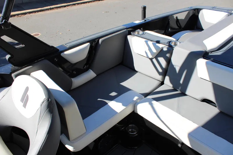 Slide: The Image of 2019 Heyday WTSurf boat interior with gray and white seating, cup holders, and sleek design. - 23