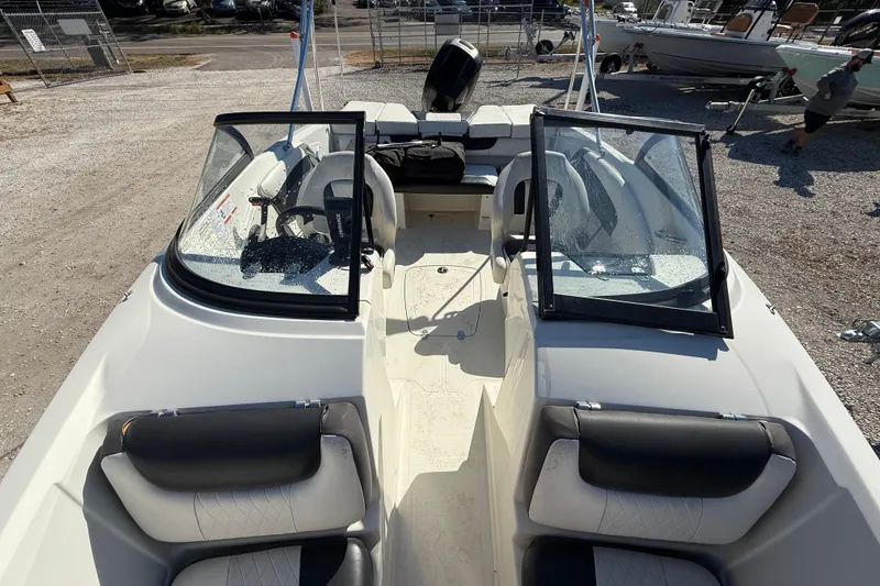 Slide: The Image of 2016 Tahoe 550TF boat interior with seating and steering wheel, parked on gravel. - 11