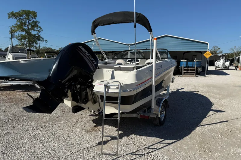 Slide: The Image of 2016 Tahoe 550TF boat with Mercury engine on trailer in sunny outdoor setting. - 2