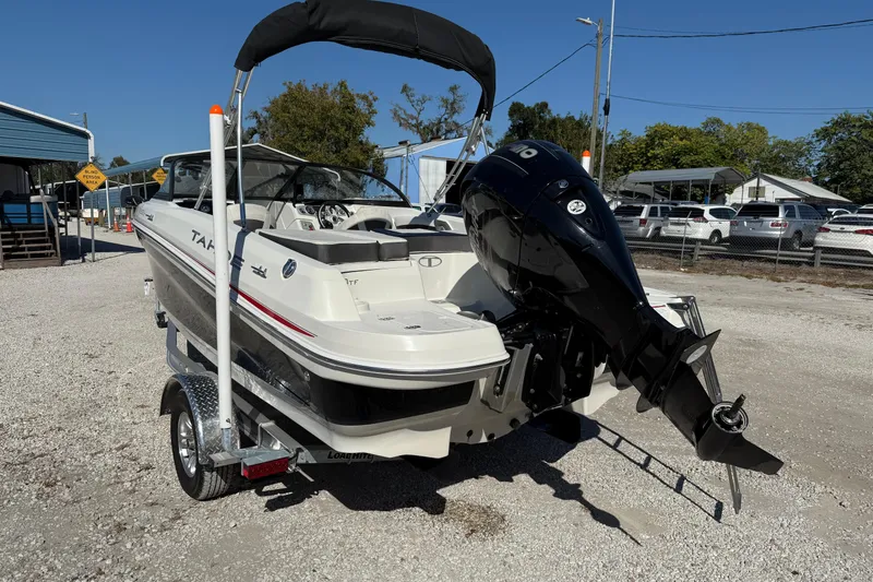 Slide: The Image of 2016 Tahoe 550TF boat on trailer with outboard motor, parked outdoors. - 3