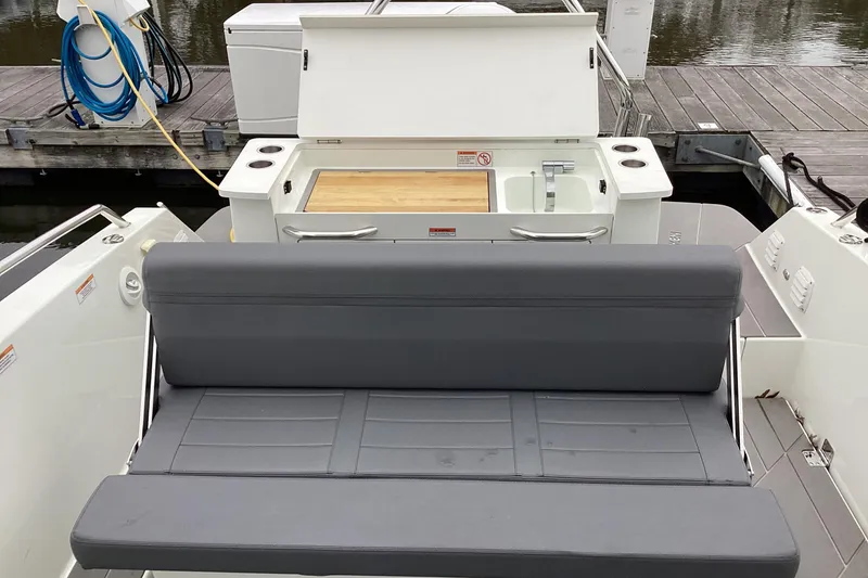 Slide: The Image of 2024 Quarken 27 T-Top V2 boat interior with seating and kitchenette area. - 12