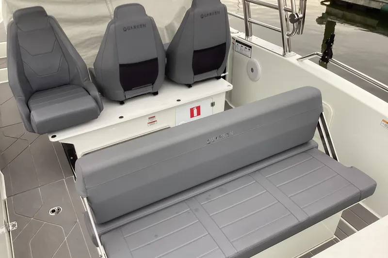 Slide: The Image of 2024 Quarken 27 T-Top V2 boat interior with gray seating and modern design. - 14