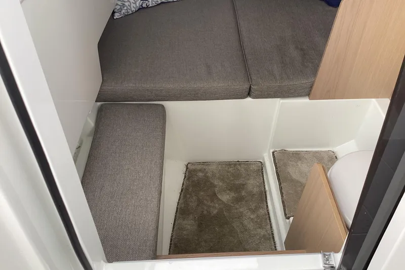 Slide: The Image of Interior cabin of 2024 Quarken 27 T-Top V2 with gray cushions and carpeted floor. - 30