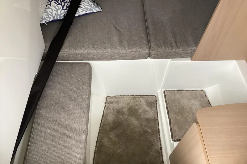 Slide: The Image of 2024 Quarken 27 T-Top V2 interior with gray cushions and beige carpeting. - 7