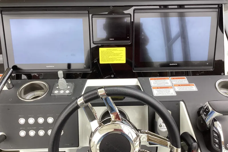 Slide: The Image of Control panel of 2024 Quarken 27 T-Top V2 with Garmin displays and steering wheel. - 8