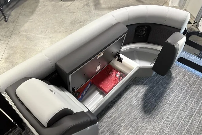 Slide: The Image of 2026 Premier 230 Sunsation RL boat interior with open storage compartment and cushioned seating. - 12