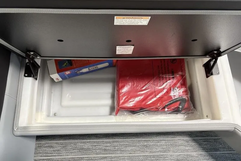 Slide: The Image of Storage compartment in 2026 Premier 230 Sunsation RL boat with safety equipment. - 14