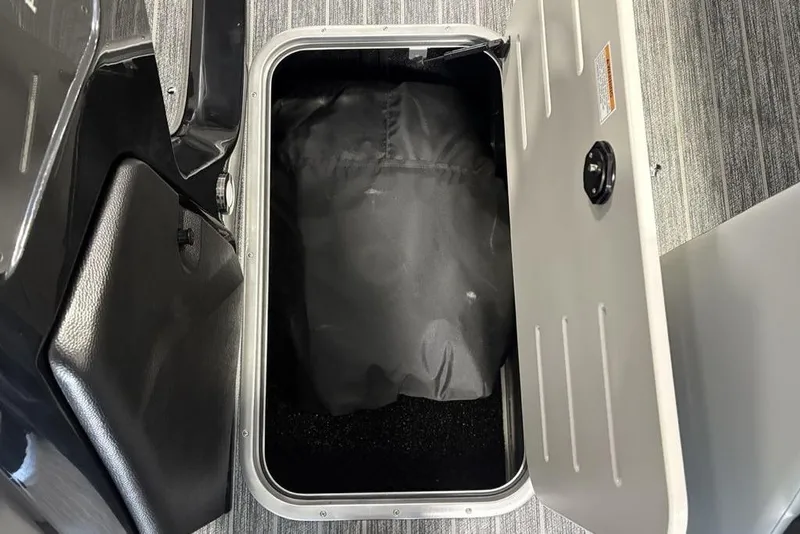 Slide: The Image of Storage compartment of 2026 Premier 230 Sunsation RL boat, open with black interior. - 17