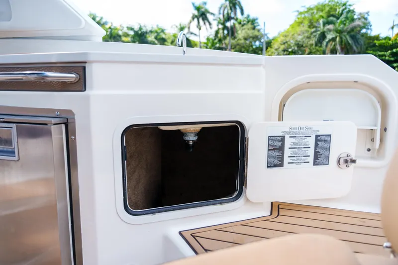 Slide: The Image of Open storage compartment on a Sea Ray boat with wooden deck and stainless steel features. - 24
