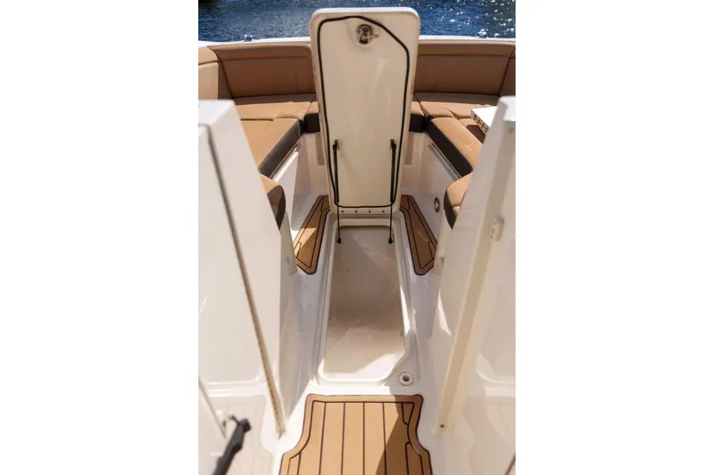 Slide: The Image of Interior view of a Sea Ray boat with tan seating and open storage compartment. - 29