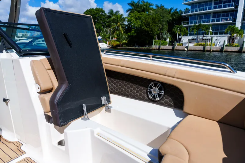 Slide: The Image of Luxury Sea Ray boat interior with tan seating, open storage, and waterfront view. - 32