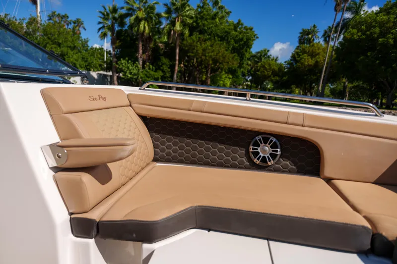 Slide: The Image of Luxurious Sea Ray boat seating with tan upholstery and speaker, surrounded by lush greenery. - 37
