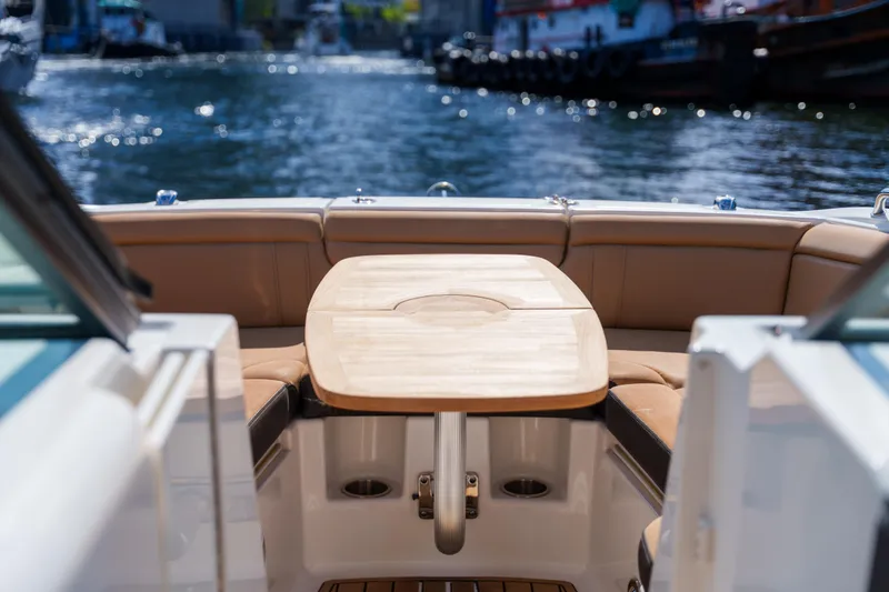 Slide: The Image of Luxurious Sea Ray boat interior with wooden table and leather seating on a sunny day. - 40