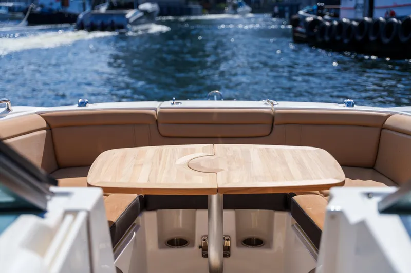 Slide: The Image of Luxury Sea Ray boat interior with wooden table and cushioned seating, overlooking calm water. - 41