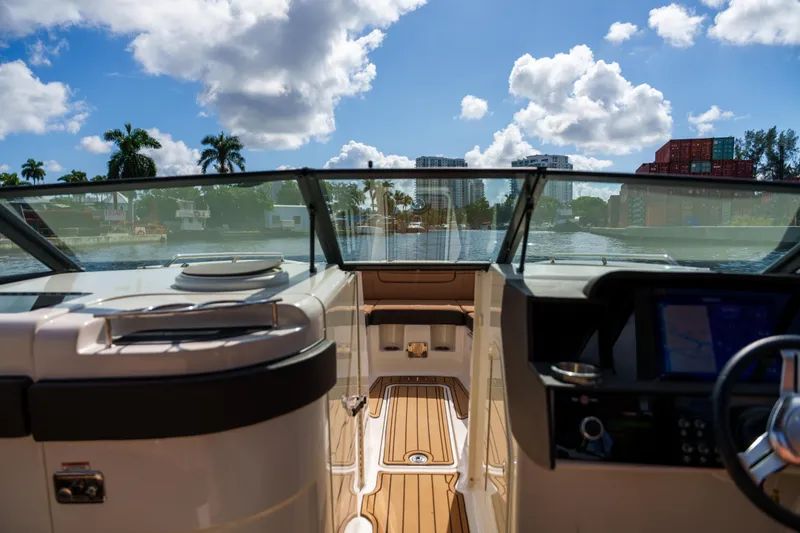 Slide: The Image of Interior view of a Sea Ray boat with a scenic waterfront backdrop. - 9