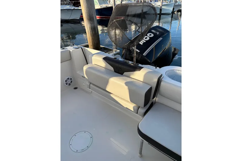 Slide: The Image of 2023 Sailfish 241 CC boat interior with seating and outboard motor at dock. - 3