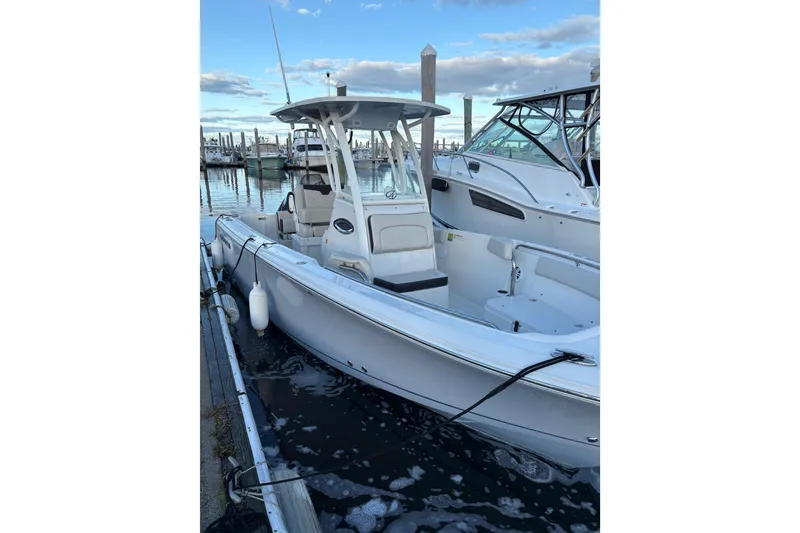 Slide: The Image of 2023 Sailfish 241 CC boat docked at marina, clear sky background. - 5