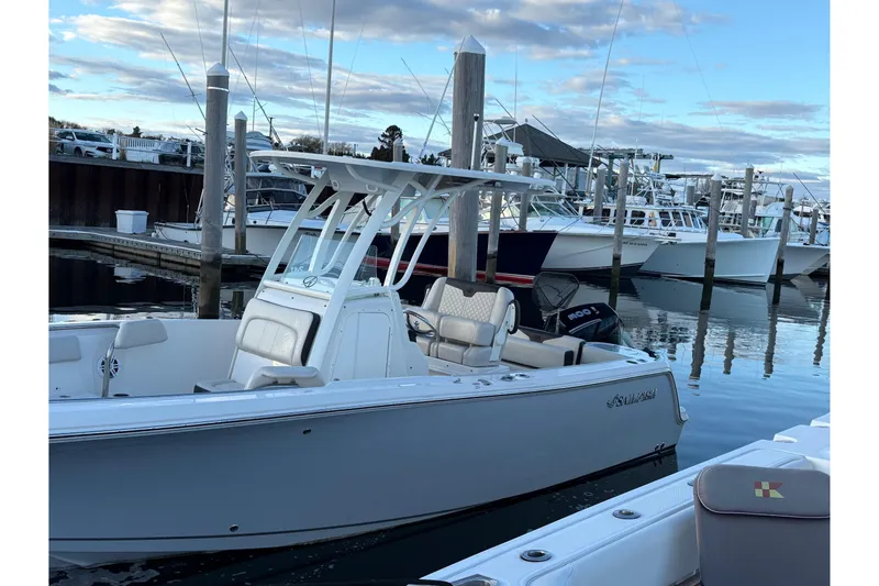 Slide: The Image of 2023 Sailfish 241 CC boat docked at marina under blue sky. - 7