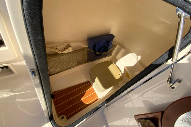 Slide: The Image of 2014 Grady-White Freedom 225 boat interior with storage and portable toilet. - 28