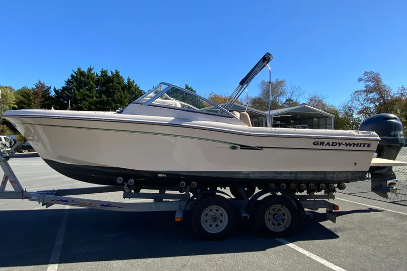 Slide: The Image of 2014 Grady-White Freedom 225 boat on trailer, parked outdoors under clear blue sky. - 6