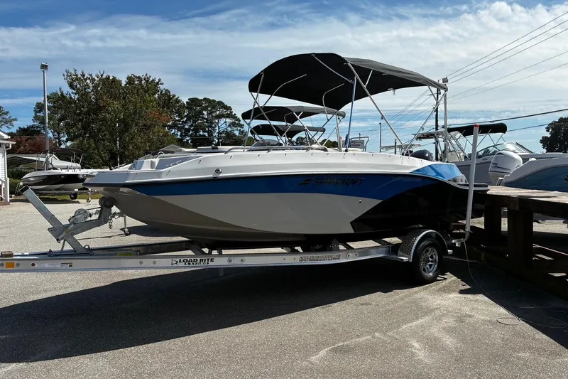 Slide: The Image of 2026 Starcraft SVX 191 OB boat on trailer, parked outdoors under a clear sky. - 3