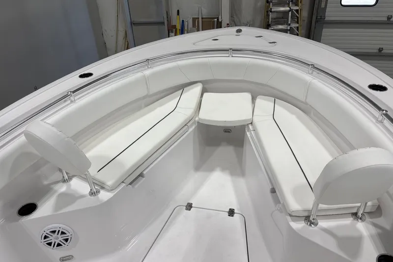 Slide: The Image of 2025 Sportsman Open 232 Center Console boat interior with white cushioned seating. - 5