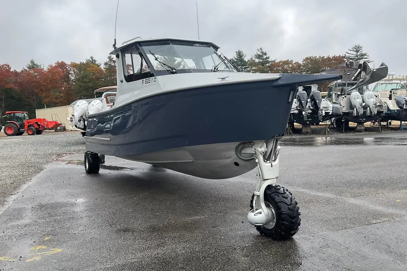 The Image of 2023 Sealegs 8.5 Alloy Cabin boat with wheels on a wet surface, overcast sky. - 0