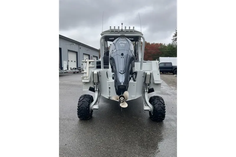 Slide: The Image of 2023 Sealegs 8.5 Alloy Cabin boat with wheels, parked outdoors on a cloudy day. - 2