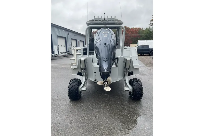 Slide: The Image of 2023 Sealegs 8.5 Alloy Cabin with outboard motor and rugged wheels on wet pavement. - 9