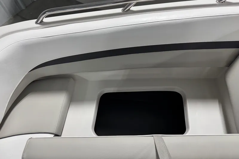 Slide: The Image of 2026 Starcraft SVX 191 OB boat interior storage compartment with white cushioned seating. - 12