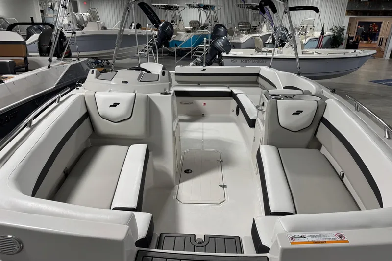 Slide: The Image of 2026 Starcraft SVX 191 OB boat interior with white seating and modern design in showroom. - 6