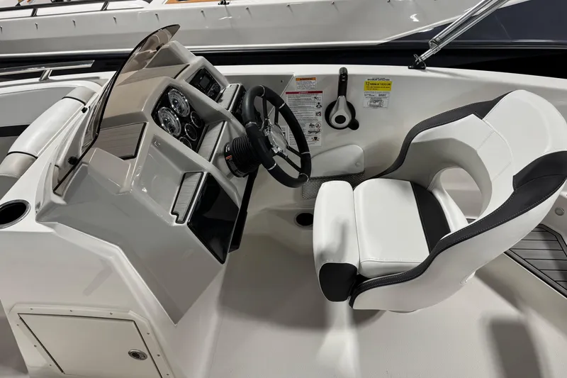 Slide: The Image of 2026 Starcraft SVX 191 OB boat cockpit with steering wheel and white captain's chair. - 9