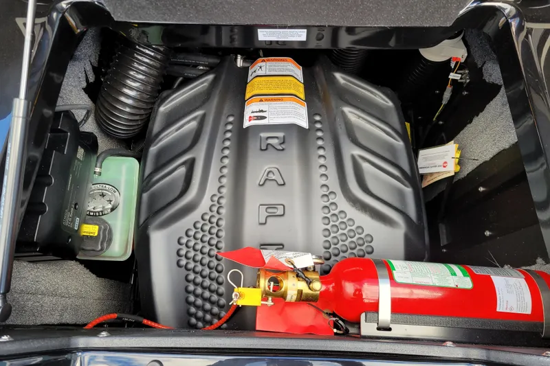 Slide: The Image of Engine compartment of 2026 Supra SL with fire extinguisher and warning labels. - 10