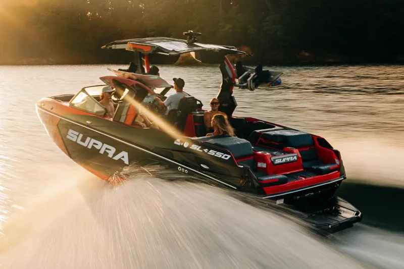 Slide: The Image of Manufacturer Provided Image: 2026 Supra SL boat cruising on a lake at sunset with passengers enjoying the ride. - 15
