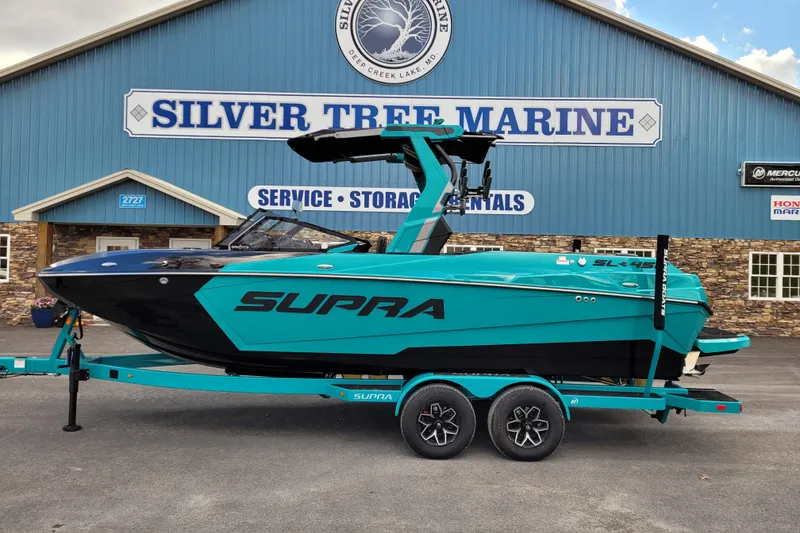 Slide: The Image of 2026 Supra SL boat in teal, parked at Silver Tree Marine. - 3