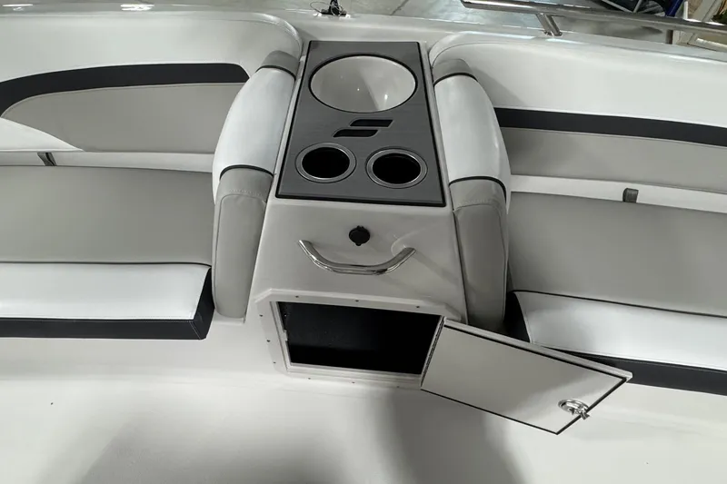 Slide: The Image of 2026 Starcraft SVX 191 OB boat interior with seating, cup holders, and open storage compartment. - 15