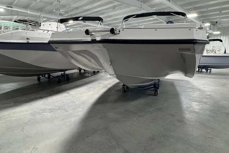 Slide: The Image of 2026 Starcraft SVX 191 OB boat in showroom, side view, on wheeled supports. - 4