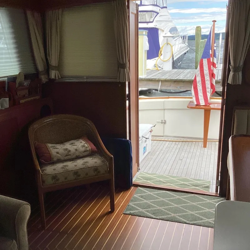 Slide: The Image of Interior view of 1991 MDI Sedan Flybridge with American flag and docked boat outside. - 12
