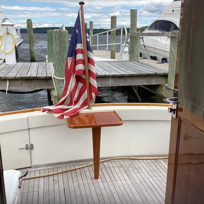 Slide: The Image of 1991 MDI Sedan Flybridge boat with American flag at dockside. - 13