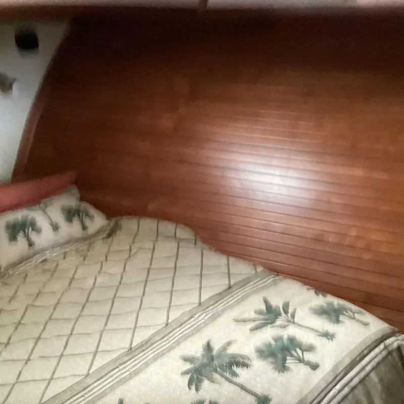 Slide: The Image of Cozy cabin interior with wooden paneling and tropical-themed bedding in 1991 MDI Sedan Flybridge. - 15