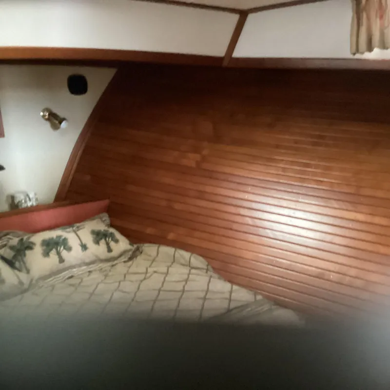 Slide: The Image of Cozy wooden interior of 1991 MDI Sedan Flybridge with bed and palm tree pillows. - 19