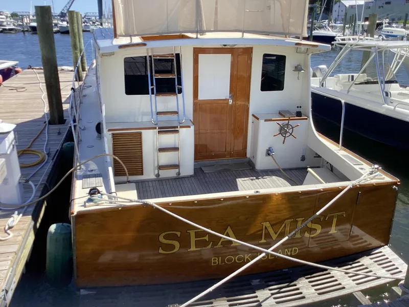 Slide: The Image of 1991 MDI Sedan Flybridge boat named "Sea Mist" docked at a marina. - 2