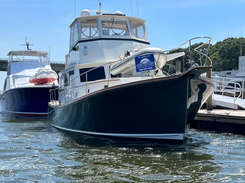 Slide: The Image of 1991 MDI Sedan Flybridge boat docked at marina, sunny day, calm water. - 26