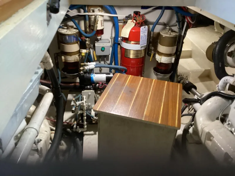 Slide: The Image of Engine room of a 1991 MDI Sedan Flybridge with fire extinguisher and mechanical components. - 30