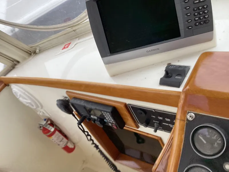 Slide: The Image of 1991 MDI Sedan Flybridge dashboard with navigation equipment and fire extinguisher. - 36