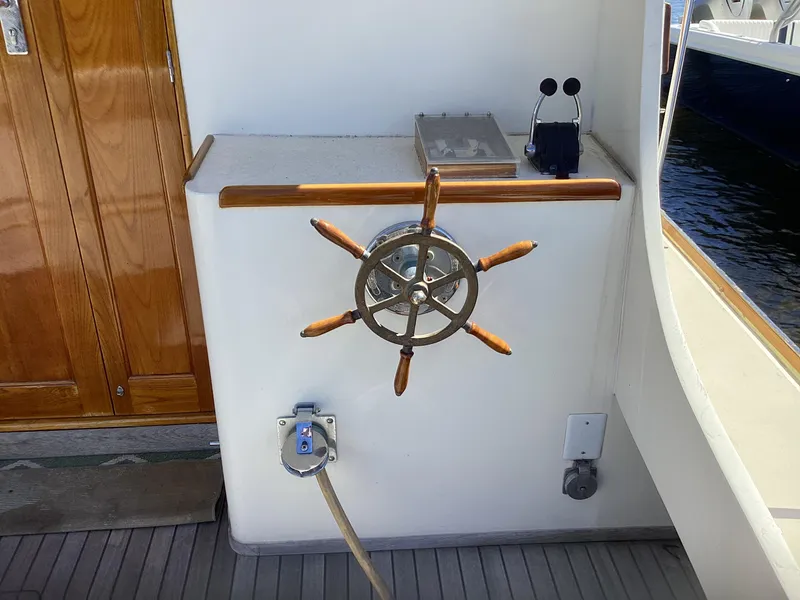 Slide: The Image of Wooden ship wheel on 1991 MDI Sedan Flybridge, with control panel and nautical equipment. - 39