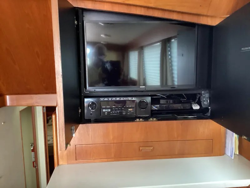 Slide: The Image of 1991 MDI Sedan Flybridge interior with built-in TV and audio system in wooden cabinet. - 4