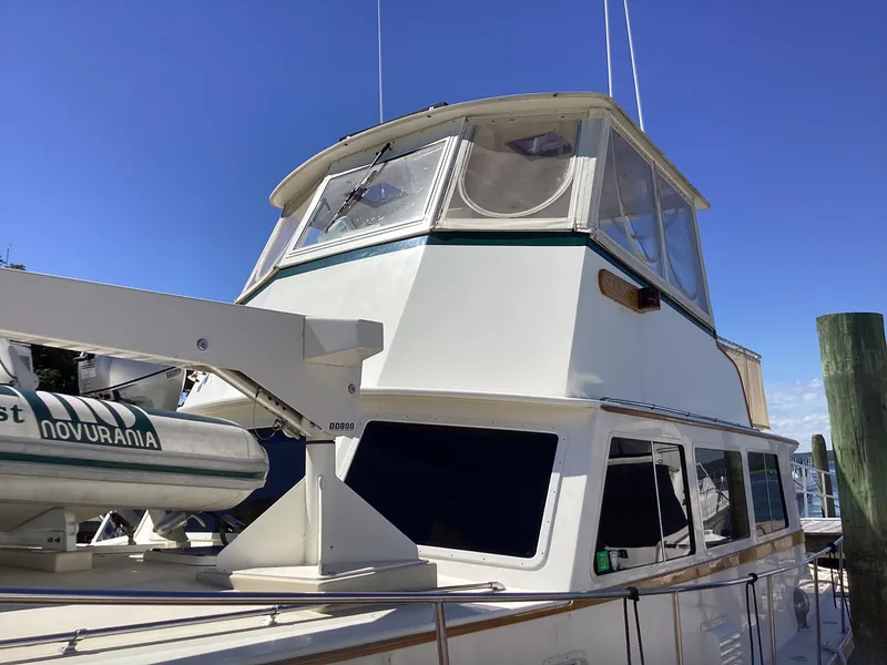 Slide: The Image of 1991 MDI Sedan Flybridge boat docked, featuring upper deck and clear blue sky. - 40